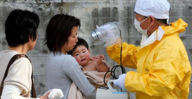 Personal médico comprueba los niveles de radiación de una mujer y su hijo en Kawamata en la región de Fukushima (Japón). / EFE