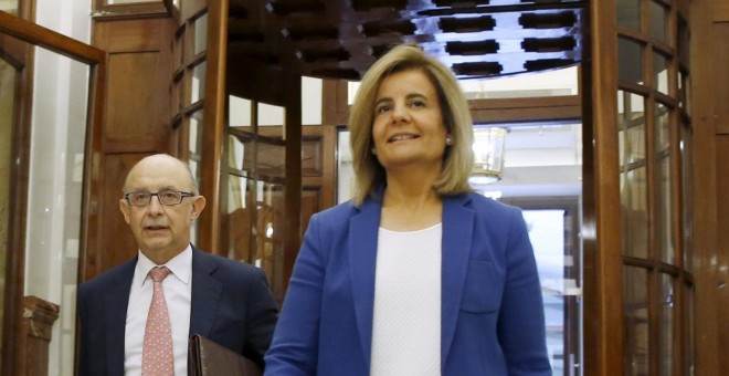 La ministra de Empleo, Fátima Báñez, con el ministro de Hacienda, Cristóbal Montoro, a su llegada al Congreso donde tiene lugar por segundo día el debate de totalidad del proyecto de Ley de Presupuestos para 2016. EFE/Sergio Barrenechea