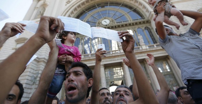 Cientos de inmigrantes protestan y muestran sus billetes a las puertas de la estación de Keleti, en Budapest. REUTERS