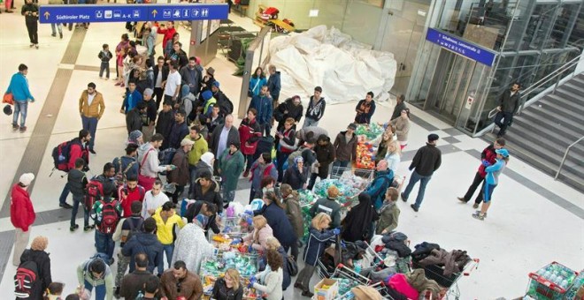 Grupos de voluntarios reparten comida, agua y ropa a los refugiados llegados a la estación de tren de Salzburgo, en Austria. EFE