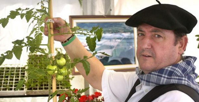 Un 'baserritarra' (agricultor) muestra una mata de tomate en la inauguración de una feria de agricultura en Bilbao. / EFE