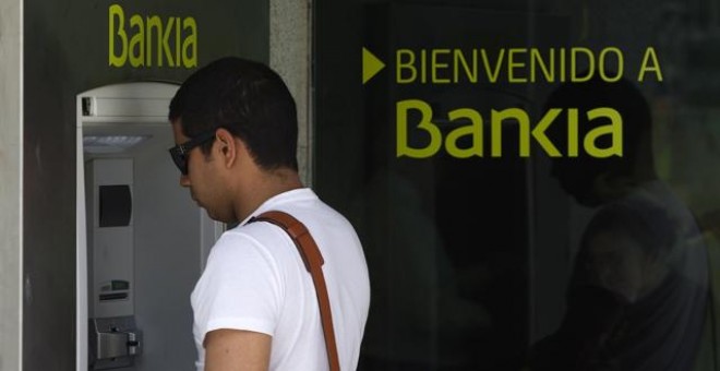 Un hombre retira dinero en un cajero de Bankia. EFE