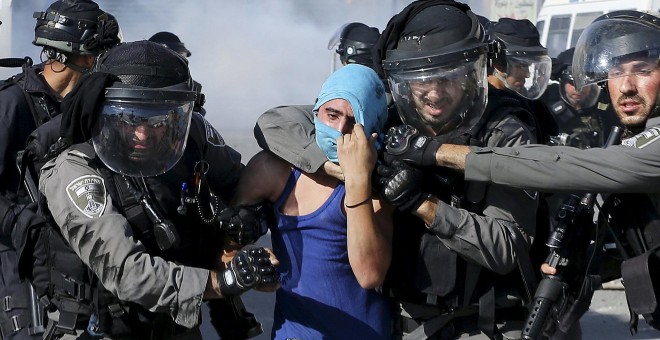 Un policía israelí detienen a un manifestante palestino durante los enfrentamientos que se produjeron en el campamento de refugiados de Shuafat, cerca de Jerusalén./ REUTERS/ Ammar Awad