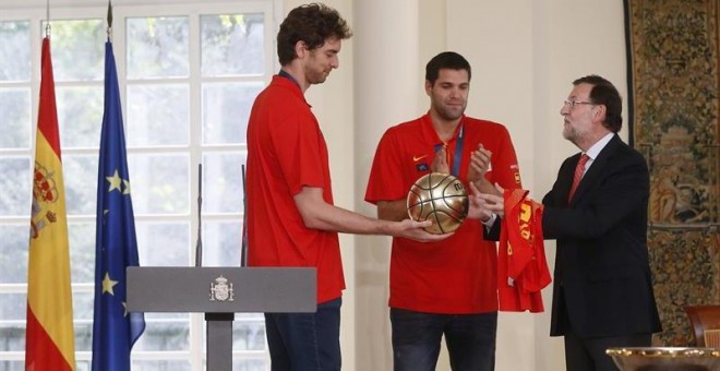 Pau Gasol, junto a Felipe Reyes, le entrega un balón de oro a Mariano Rajoy en La Moncloa. /EFE