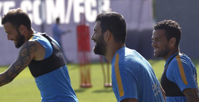 Arda Turan junto a los compañeros del FC Barcelona Alex Vidal y Dani Alves, durante el entrenamiento de la plantilla en la Ciudad Deportiva Joan Gamper. EFE/Alejandro García