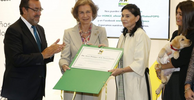 El presidente de la ONCE, Miguel Carballeda, y la reina Sofía entregan un diploma a Teresa Domínguez, en cuyo familia se han educado 28 cachorros de perros guía en los últimos 19 años, en un acto con motivo del 25 aniversario de la Fundación ONCE del Perr