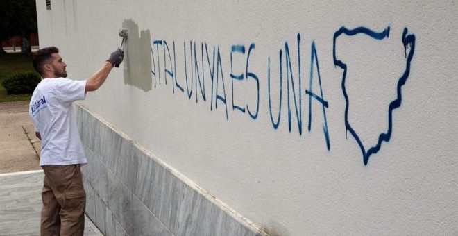 Un operario de la brigada de limpieza borran una pintada en el colegio electoral situado en el Centro Cultural Mira-sol de San Cugat donde ha votado el cabeza de lista de Junts pel Sí, Raül Romeva. /EFE