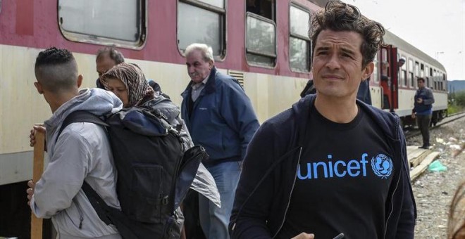 El embajador de buena voluntad de Unicef y actor Orlando Bloom observa a los refugiados que suben a bordo de un tren con destino a la frontera serbia, en Gevgelija (Macedonia). EFE/Georgi Licovski