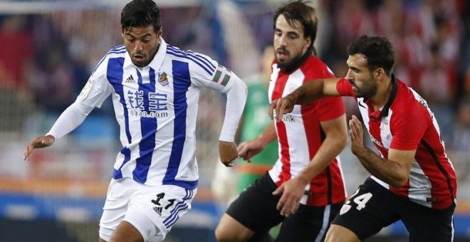 Vela trata de escapar de Beñat y Balenziaga durante el partido entre Real Sociedad y Athletic de la última jornada de Liga. EFE/Juan Herrero