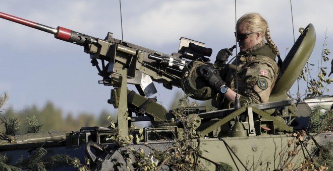 A Danish Army soldier takes off her helmet during a break in the "Silver Arrow 2015" NATO military exercise, at a training field near Adazi, Latvia, September 27, 2015. Approximately 2,400 personnel from six nations are participating, said Latvia's Minist