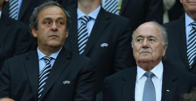 Blatter junto a Platini en el palco de honor de un estadio.