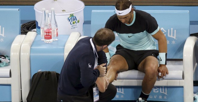 Rafa Nadal recibe atención de un masajista en su pie durante la final del Open de Pekín. REUTERS/Jason Lee