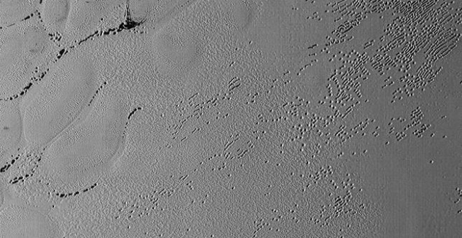 Miles de hoyos salpican el suelo de hielo de hidrógeno de Plutón. /NASA