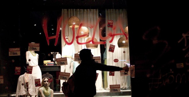 Un hombre realiza pintadas en un escaparate durante una de las dos huelga generales de 2012 en Madrid.- JAIRO VARGAS