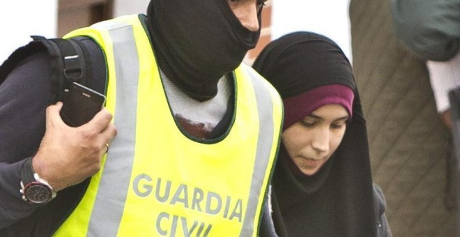 Efectivos de la Guardia Civil acompañan a la joven onubense de 22 años detenida en el aeropuerto de Madrid-Barajas cuando intentaba viajar para integrarse en el Estado Islámico. EFE / Julián Pérez