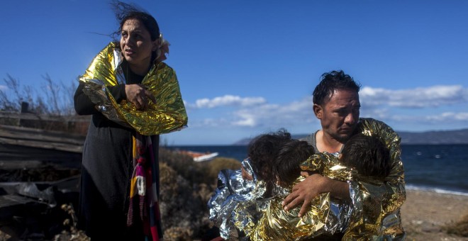 Una familia siria se protege del frío en la playa de la isla griega de Lesbos, antes de llegar al campo de refugiados de Kara Tepe.- JAVI JULIO / NERVIO FOTO