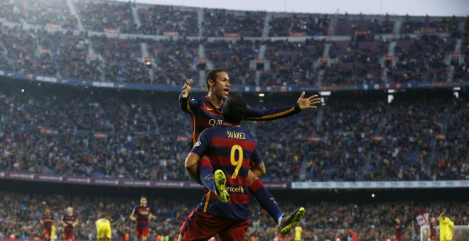 El delantero uruguayo Luis Suarez levanta a su compañero Neymar, tras su segundo gol frente al Villarreal en el Camp Nou. REUTERS/Albert Gea