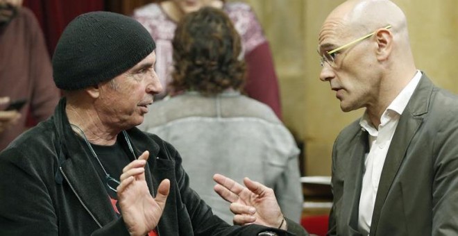 Los diputados de Junts pel Sí, Raül Romeva y Lluis Llach, en el hemiciclo del Parlament de Catalunya./ EFE