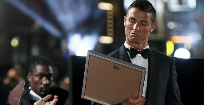 Cristiano al recibir un cuadro en la alfombra roja de la premiere de su película. /REUTERS