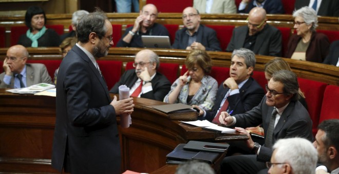 El cabeza de lista de la CUP, Antonio Baños, pasa junto al candidato de Junts pel Sí y president en funciones, Artur Mas, tras su intervención en el debate de la segunda votación de investidura tras las elecciones del 27-S. REUTERS/Albert Gea