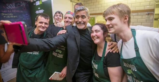 George Clooney posa con trabajadores de la cafetería Social Bite Cafe, en Edimburgo, Escocia. EFE/Jeff Holmes