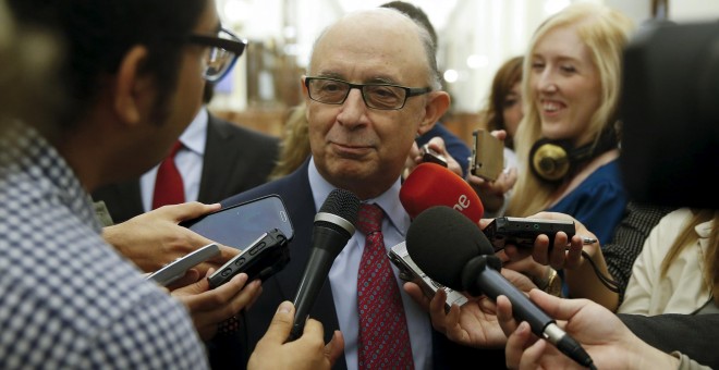 El ministro de Hacienda,  Cristóbal Montoro, rodeado de periodistas en los pasillos del Congreso, tras el último pleno de la legislatura. REUTERS/Andrea Comas