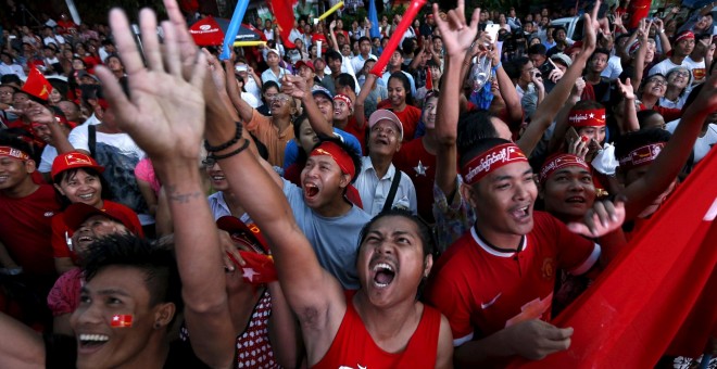 Seguidores del partido de la oposición birmana siguiendo la evolución de la noche electoral, el pasado día 9. /REUTERS