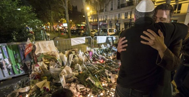 Dos hombres se abrazan junto a la sala Bataclan durante la vigilia en honor de las víctimas de los atentados. - EFE