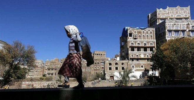 Una niña camina junto a edificios históricos destruidos por los bombardeos de la coalición árabe liderada por Arabia Saudí en Saná, Yemen. Las autoridades del país planean la reconstrucción de dos edificios destruidos el pasado 12 de junio. La Organizació