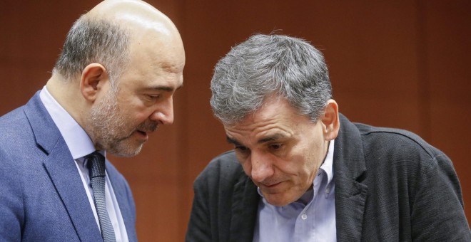 El comisario europeo de Asuntos Económicos y Financieros, Pierre Moscovici, conversa con el ministro griego de Finanzas Euclides Tsakalotos durante la reunión del Eurogrupo en la sede del Consejo Europeo en Bruselas.- EFE