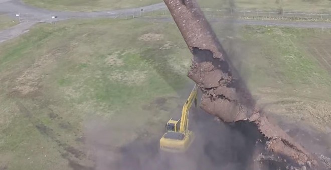 Momento en el que la chimenea se precipita contra la excavadora que la tiraba