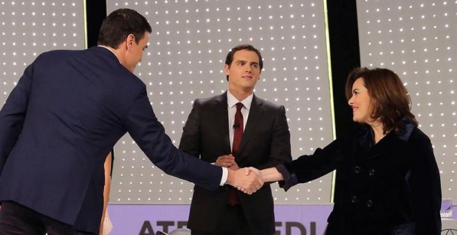 El secretario general del PSOE, Pedro Sánchez (i) saluda a la vicepresidenta del Gobierno y candidata por Madrid al Congreso, Soraya Sáenz de Santamaría, en presencia del presidente de Ciudadanos, Albert Rivera (c) antes del debate televisivo entre los ca