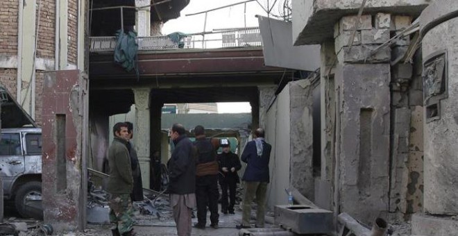 Dos agentes afganos junto al cráter creado con la explosión del coche bomba en Kabul que ha causado la muerte de dos policías nacionales. Al menos tres talibanes fueron abatidos dentro de la Embajada española en Kabul EFE/EPA/JAWAD JALAL