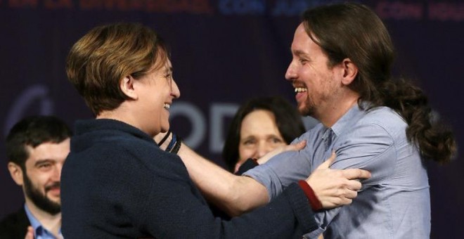 Pablo Iglesias saluda a Ada Colau durante el acto político de Podemos en la Caja Mágica de Madrid. / EFE