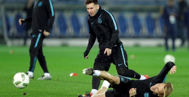 El delantero argentino del FC Barcelona, Lionel Messi (c) y su compañero, el croata Ivan Rakitic (abajo), participan en un entrenamiento del equipo en el Estadio Internacional de Yokohama. /EFE