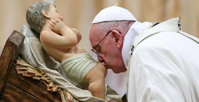 El papa Francisco besa la figura de un niño Jesús durante la Misa del Gallo. /EFE