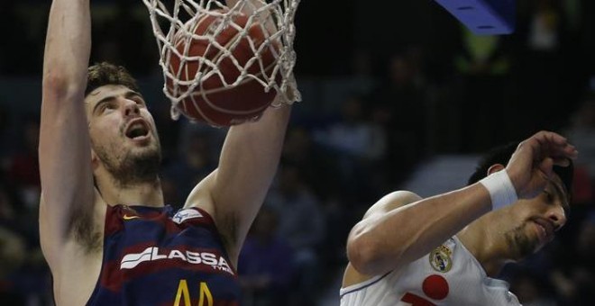 El pívot croata del FC Barcelona Lassa Ante Tomic (i) encesta ante el ala-pívot mexicano del Real Madrid Gustavo Ayón, durante el partido del decimotercera jornada de Liga que disputan en el Palacio de los Deportes de Madrid. EFE/Chema Moya