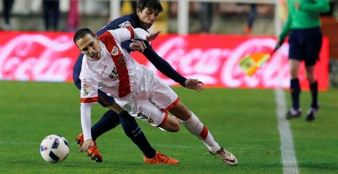 El centrocampista del Rayo Vallecano Miku (delante) lucha el balón con el centrocampista Óliver Torres, del Atlético. /EFE