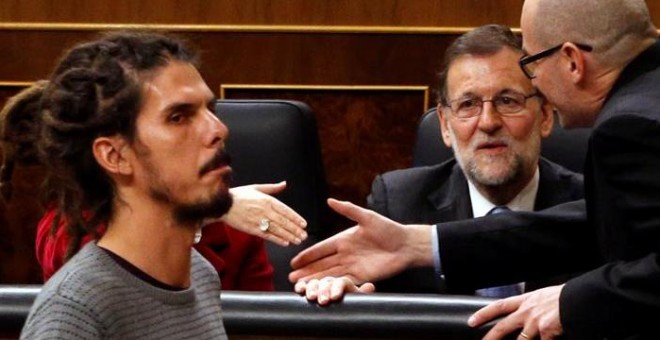 El diputado de Podemos Alberto Rodríguez (i) pasa ante el presidente del Gobierno en funciones, Mariano Rajoy, antes de votar la elección del presidente del Congreso, durante la sesión constitutiva de la Cámara Baja que supone la apertura de la XI Legisla