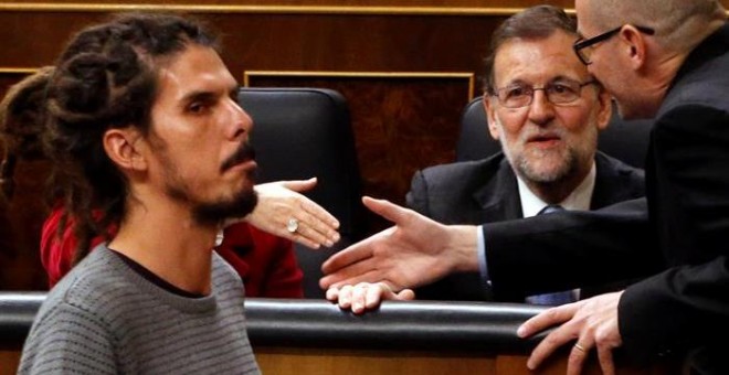 El diputado de Podemos Alberto Rodríguez (i) pasa ante el presidente del Gobierno en funciones, Mariano Rajoy, antes de votar la elección del presidente del Congreso, durante la sesión constitutiva de la Cámara Baja que supone la apertura de la XI Legisla