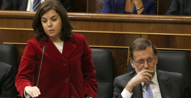 La vicepresidenta del Gobierno en funciones, Soraya Sáez de Santamaria, jura durante la sesión constitutiva de la Cámara Baja, que ha inaugurado la XI legislatura. A la derecha el presidente del Gobierno en funciones, Mariano Rajoy. EFE/J. J. Guillén