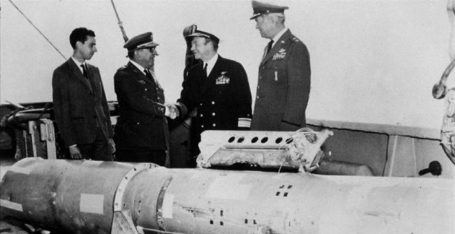 El almirante Guest estrecha la mano del general Montel junto a la cuarta bomba termonuclear rescatada del mar.