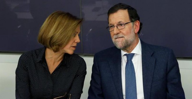 El presidente del Gobierno, Mariano Rajoy, conversa con la secretaria general del PP, María Dolores de Cospedal, durante la reunión de la Junta Directiva Nacional del PP celebrada en la sede del partido en Madrid, para aprobar las propuestas de los candid