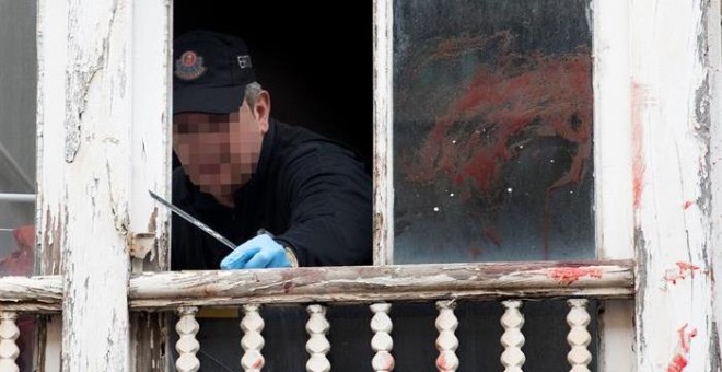 Un ertzaina toma pruebas en la ventana del domicilio del número 14 de la calle Libertad de Vitoria desde la que un hombre de 30 años ha arrojado esta madrugada a la hija de 17 meses de su pareja, tras una discusión en la que el hombre y la madre de la niñ