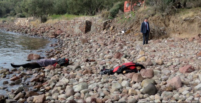 Un hombre mira los cadáveres de los refugiados víctimas del naufragio de su embargación frente a la costa turca. EFE / EPA / STR
