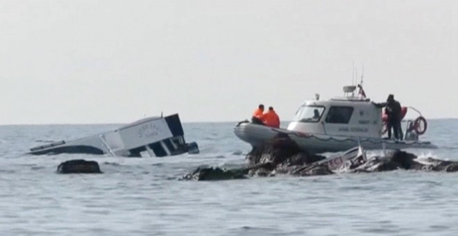 Un barco de la guardia costera turca junto a la embarcación con refugiados que ha naufragado frente a las costa de Ayvacik (Turquía). TV REUTERS / Reuters