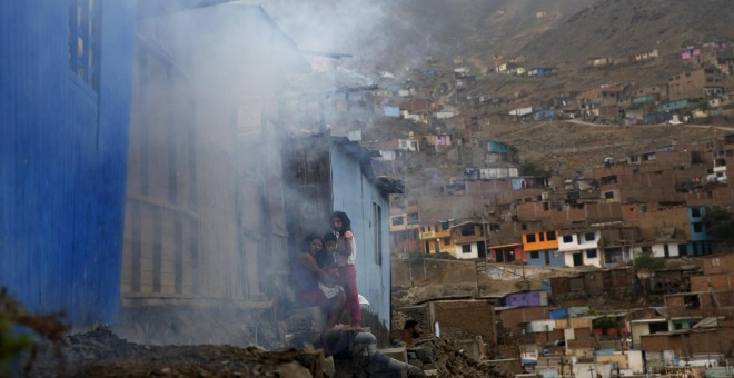 Una familia espera a que los trabajadores sanitarios terminen de fumigar su casa, durante la campaña contra el virus del Zika en una barriada de Lima (Perú). REUTERS/Mariana Bazo