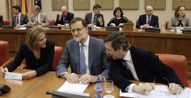 El presidente del Gobierno en funciones, Mariano Rajoy, junto a la secretaria general del PP, María Dolores de Cospedal, y el portavoz del partido en el Congreso, Rafael Hernando, durante la reunión que ha mantenido hoy con los diputados de la formación.
