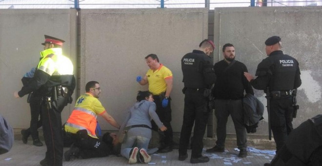 Sanitarios atienden a un herido mientras Andrés García Berrio conversa con agentes de Policía el sábado.