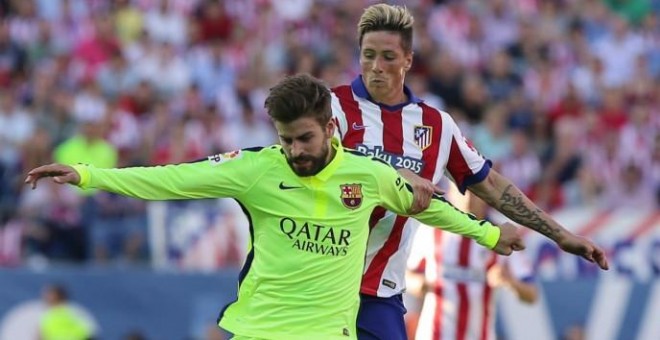 Piqué pelea por un balón con Torres.